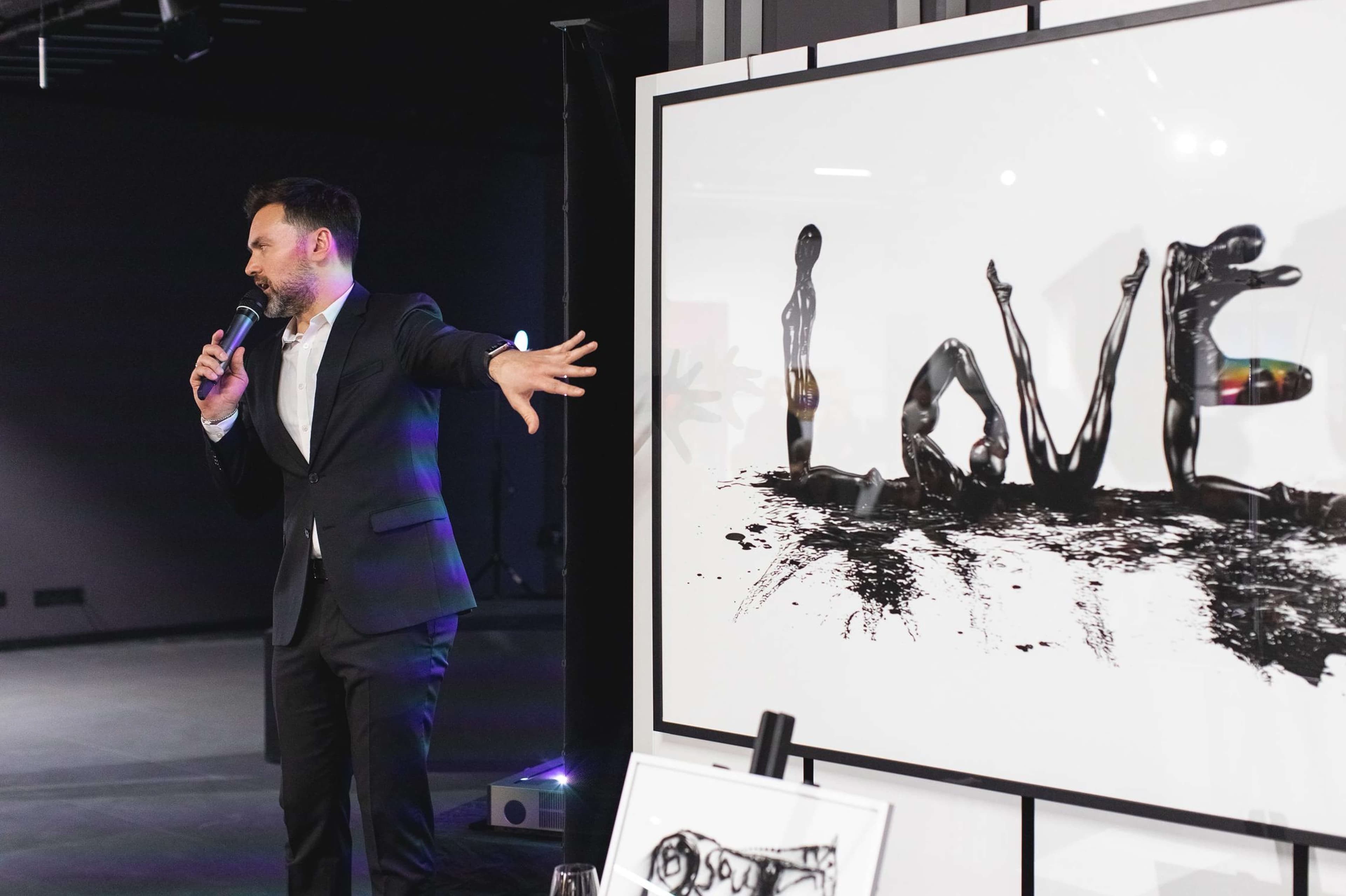 A speaker presenting a large LOVE artwork