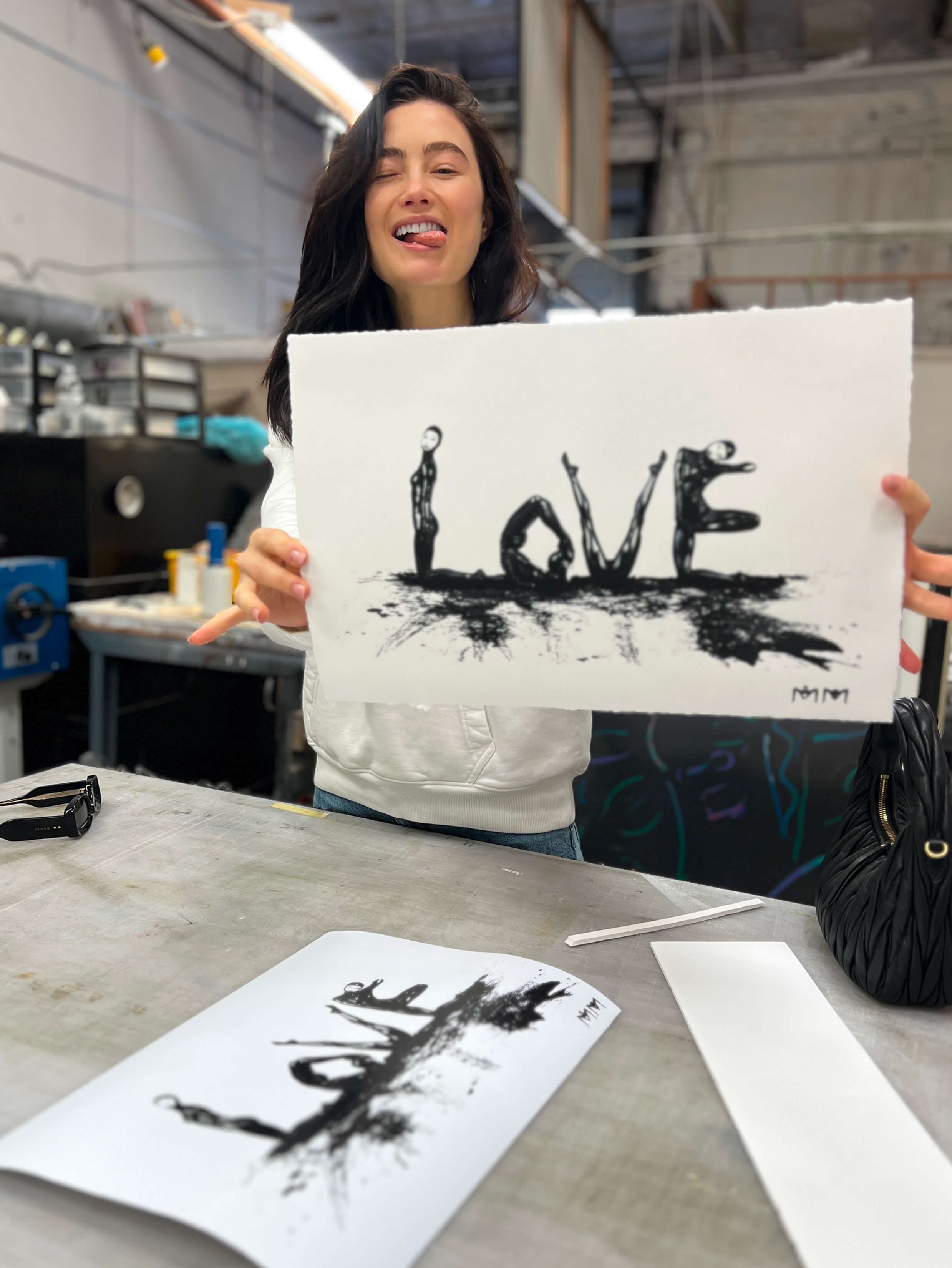 Marina Mazepa holding a LOVE print in the studio
